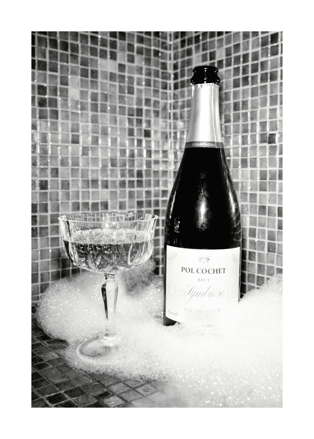Affiche monochrome dune bouteille de champagne et dune coupe remplie de bulles sur un fond de carrelage et de mousse.