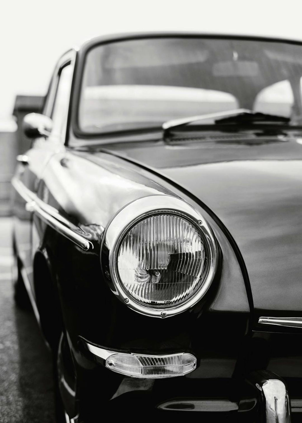 Affiche noir et blanc dune voiture classique avec un phare chromé en gros plan, ambiance vintage