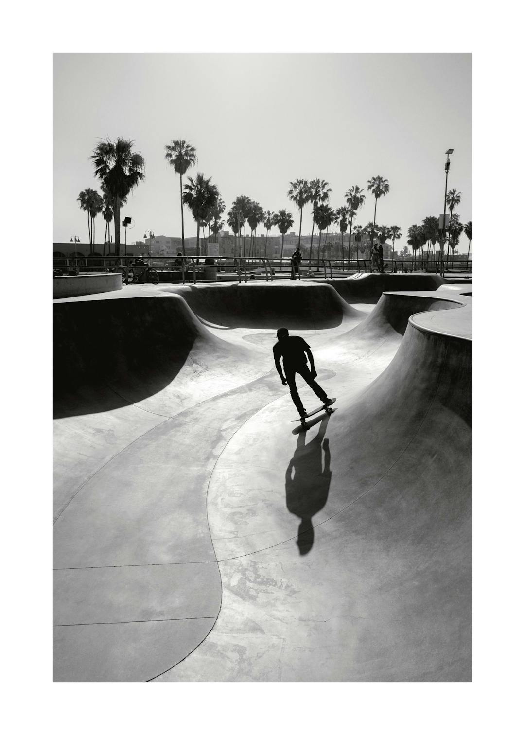 Affiche noir et blanc dun homme faisant du skateboard dans un skatepark avec des palmiers en arrière-plan