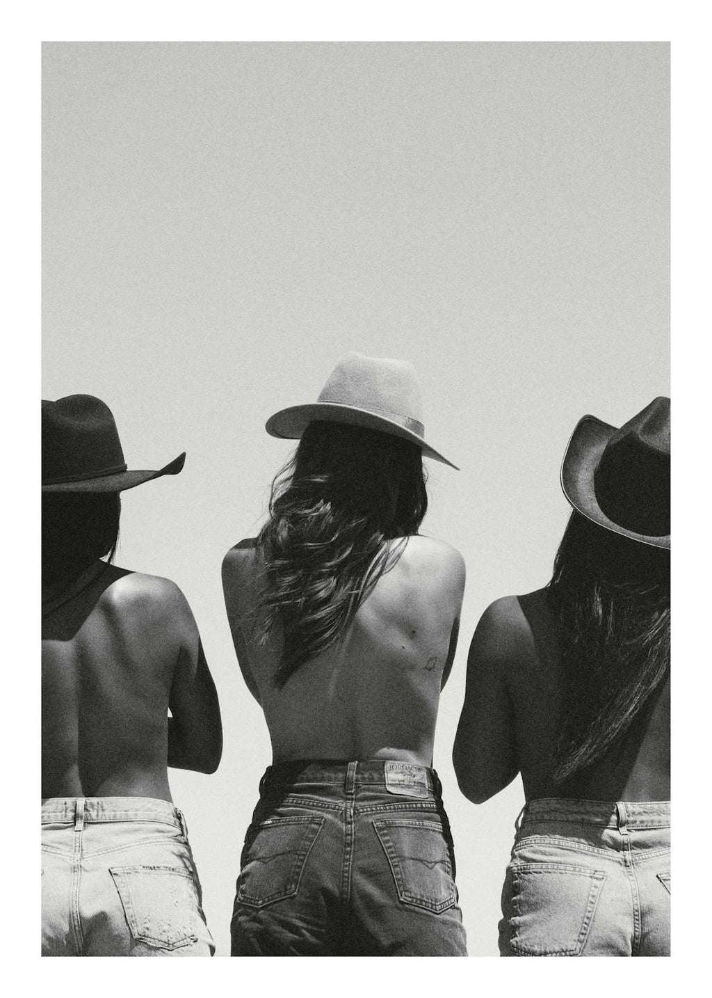 Affiche noir et blanc de trois femmes en chapeaux de cowboy et jeans, vue de dos, style Far West.