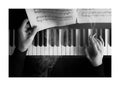 Affiche monochrome dun piano avec des mains, une cigarette fumante et des partitions de musique