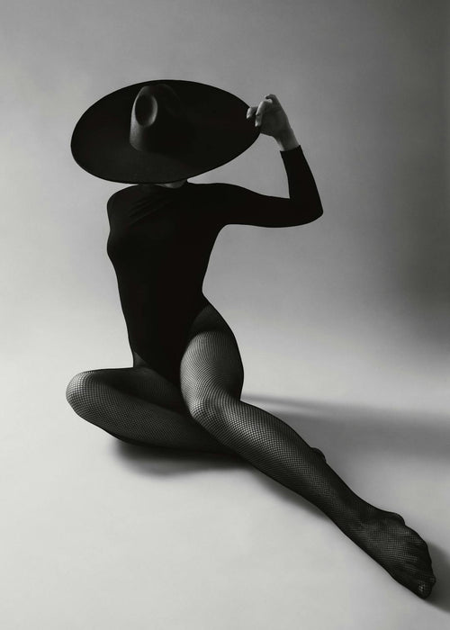 Affiche monochrome dune femme audacieuse en justaucorps et bas résille, un grand chapeau cachant son visage
