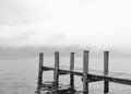 Affiche monochrome avec une jetée en bois sur un lac calme, brume en arrière-plan
