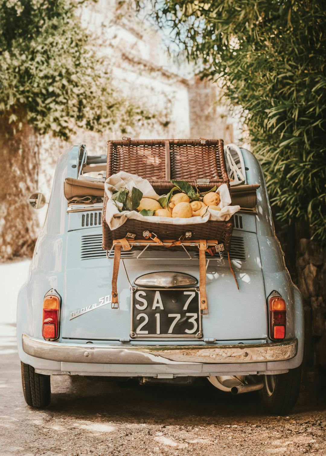 Affiche dune voiture vintage Fiat 500 bleue avec panier de pique-nique rempli de citrons à larrière