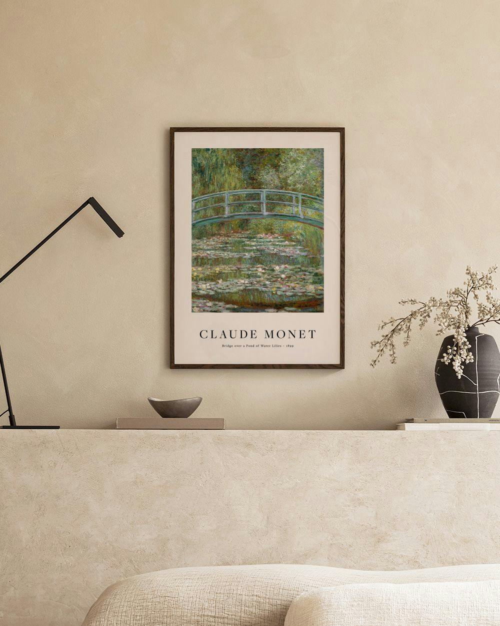 Affiche de Monet, un pont japonais vert sur un étang de nénuphars, affichée au-dessus dun canapé beige.