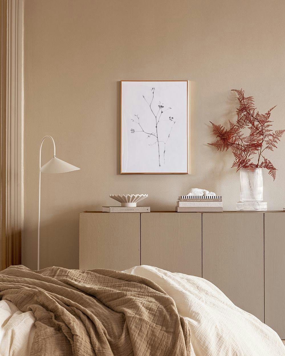 Affiche botanique minimaliste dune branche fine noire sur fond blanc, au-dessus dune étagère moderne.