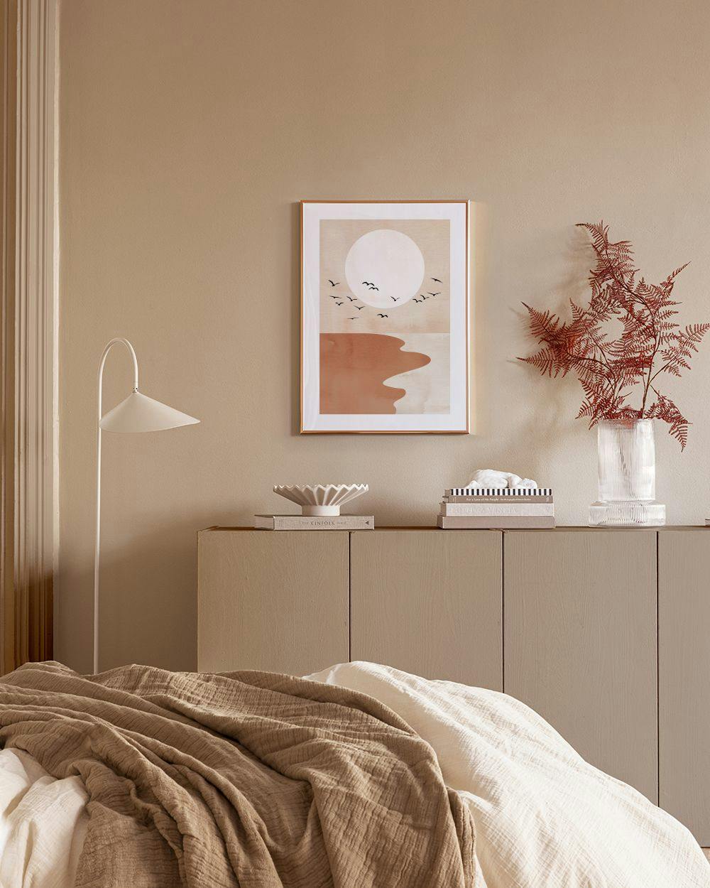 Affiche minimaliste de lever de soleil sur locéan avec des oiseaux, accrochée dans un salon moderne.