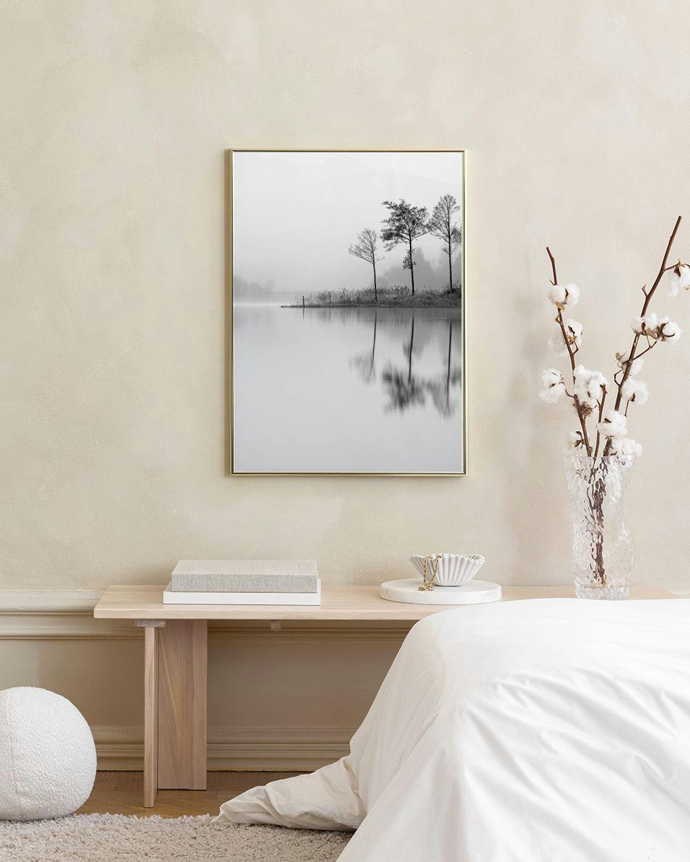 Affiche en noir et blanc darbres se reflétant dans un lac, accrochée au-dessus dun buffet gris.