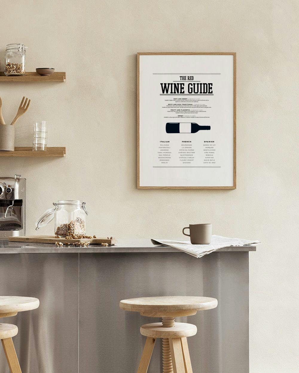 Affiche The Red Wine Guide suspendue au-dessus dune table avec nappe blanche, plantes et bols.