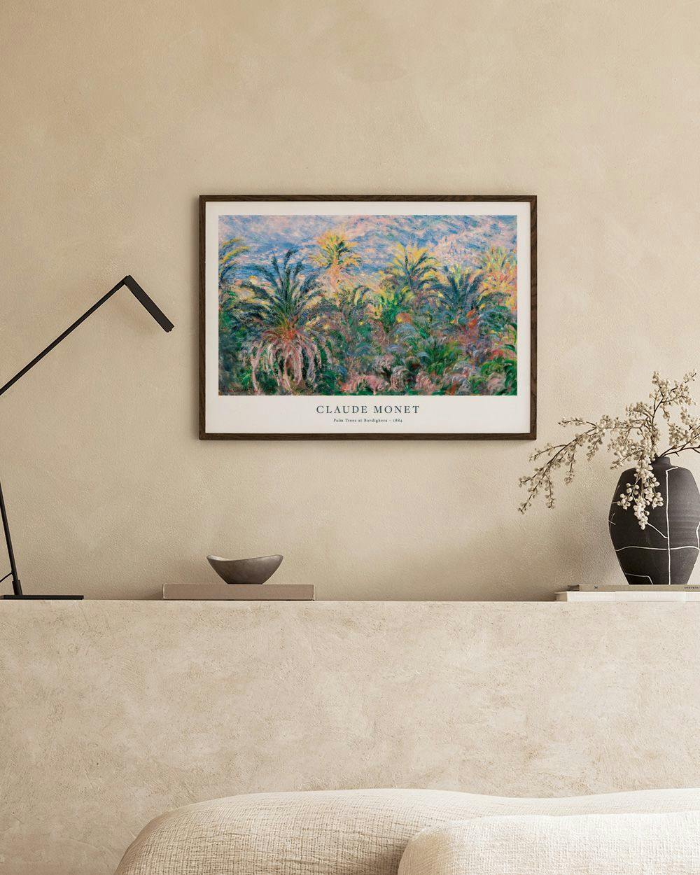 Affiche Claude Monet, Les Palmiers à Bordighera, sur mur blanc, avec vase et livres sur un meuble.