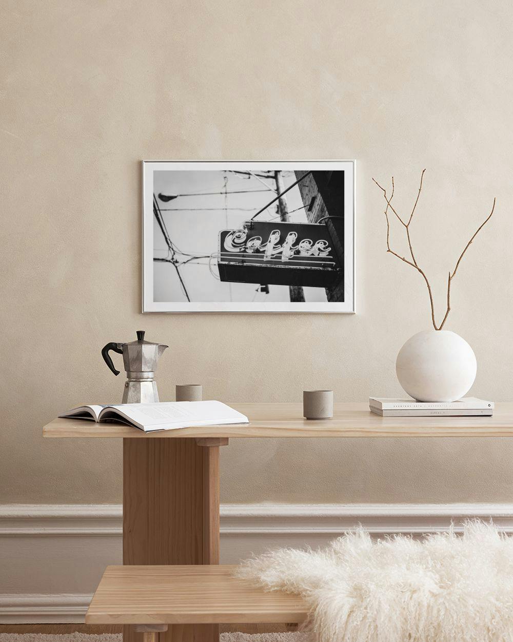 Affiche noire et blanche dun panneau néon Coffee rétro, au-dessus dune commode blanche avec des tasses.