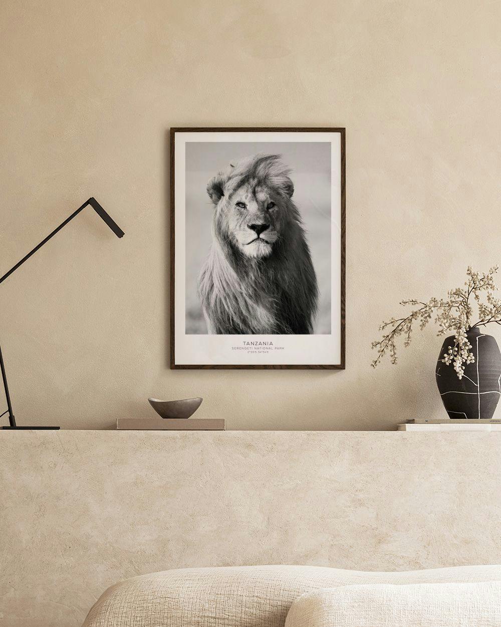 Affiche en noir et blanc d’un lion à la crinière ébouriffée, accrochée sur une grille murale dans une pièce moderne.