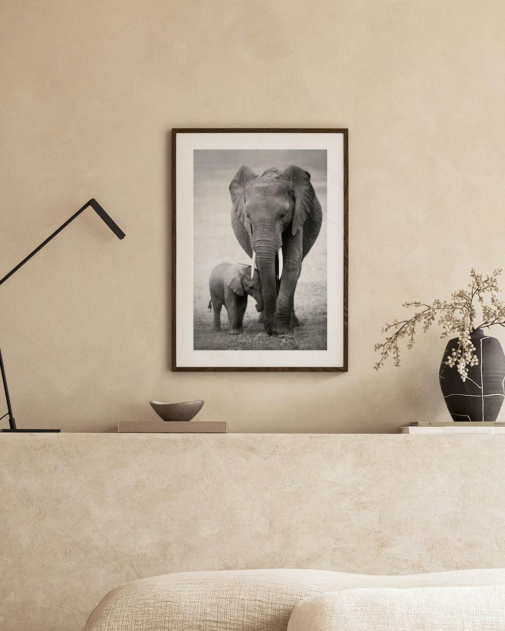Affiche noir et blanc dune mère éléphant et son éléphanteau, affichée dans un salon moderne.
