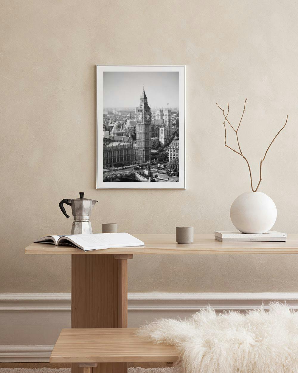 Affiche noir et blanc de Big Ben et Londres, posée sur une commode blanche avec lampe et boîtes.