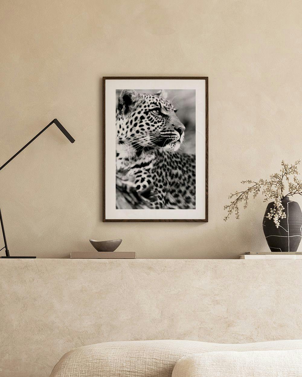 Affiche en noir et blanc d’un léopard, affichée dans un intérieur moderne au-dessus d’un meuble blanc.
