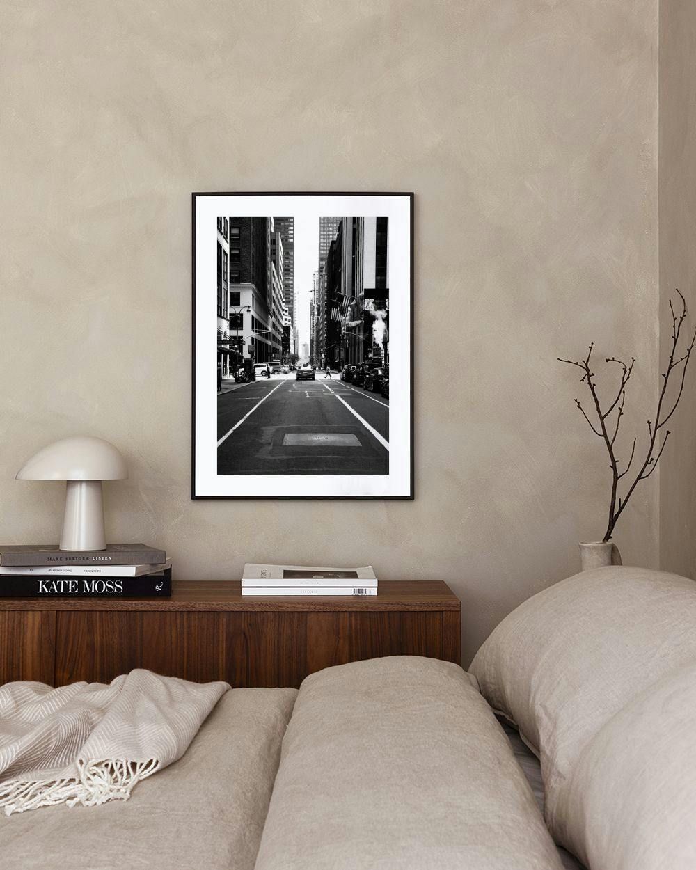 Affiche photo en noir et blanc dune rue urbaine avec circulation, au-dessus dun meuble noir moderne.