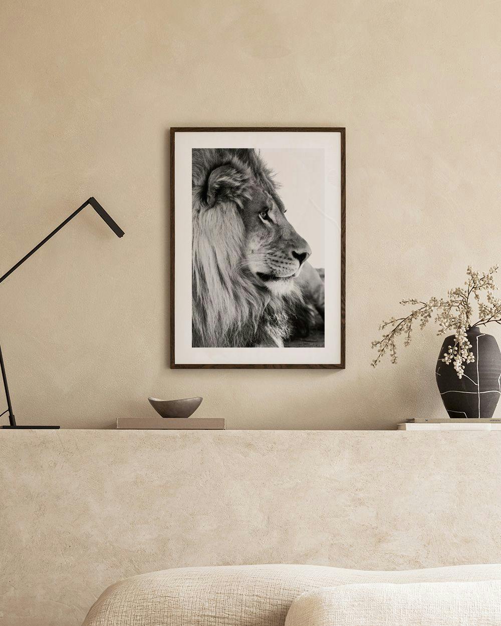 Affiche dun lion en noir et blanc, accrochée au-dessus dun meuble en bois dans un salon moderne.