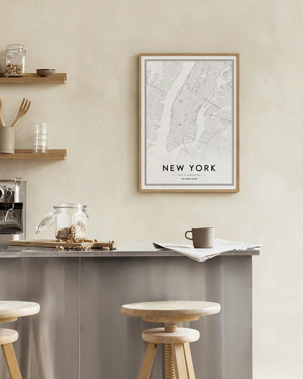 Affiche de carte de New York en noir et blanc, accrochée dans un bureau moderne avec une commode blanche et une chaise.