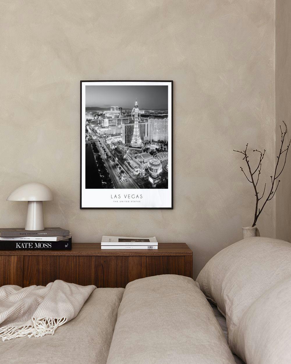 Affiche de la ville de Las Vegas en noir et blanc, posée sur une console noire avec des livres et une plante verte.