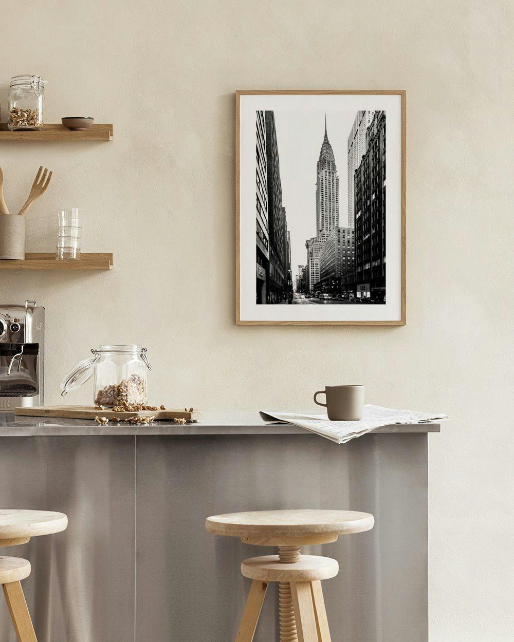 Affiche noire et blanche du Chrysler Building à New York, exposée sur une étagère avec une lampe et des vases.