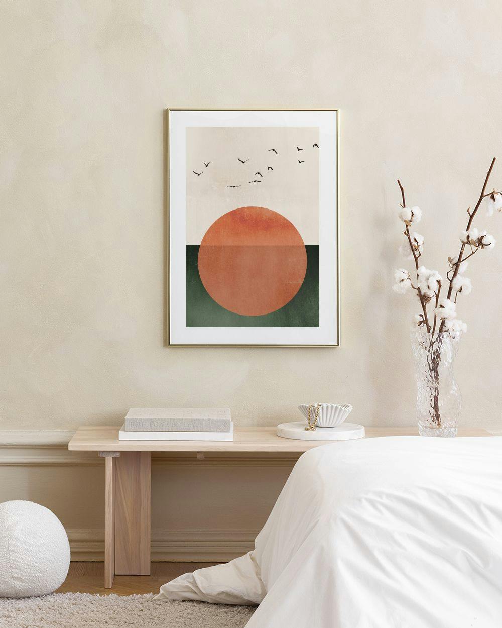 Affiche dun coucher de soleil abstrait avec des oiseaux, accrochée au-dessus dun meuble vert.