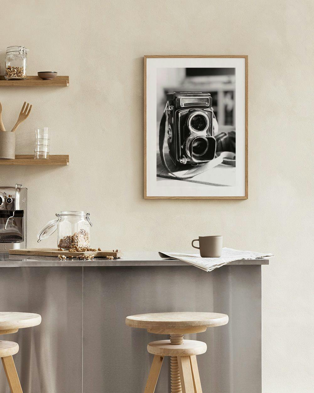 Affiche photo noir et blanc dun appareil photo vintage, affichée dans un salon moderne.