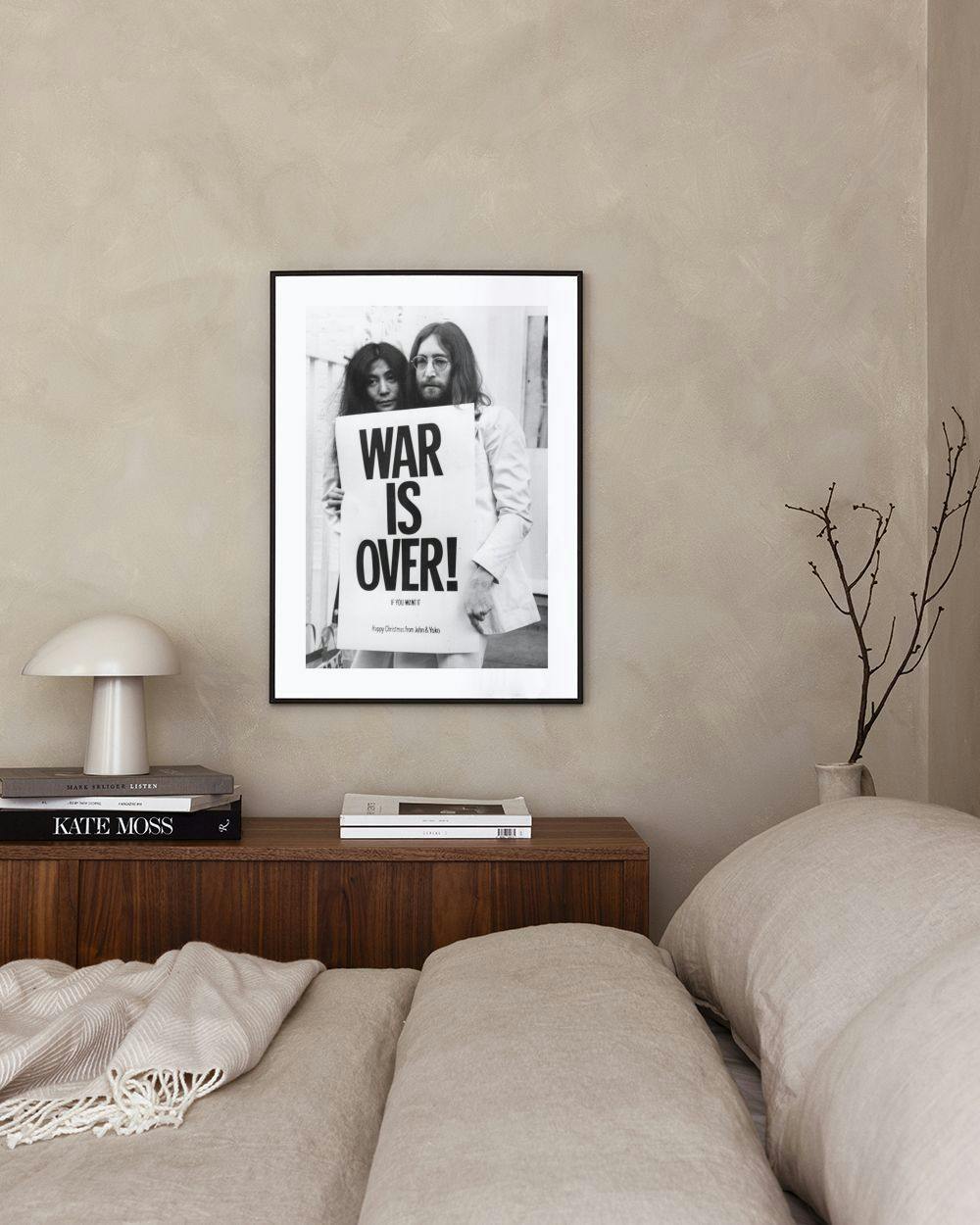 Affiche en noir et blanc de John Lennon et Yoko Ono tenant une pancarte WAR IS OVER, accrochée au-dessus dun meuble blanc dans u