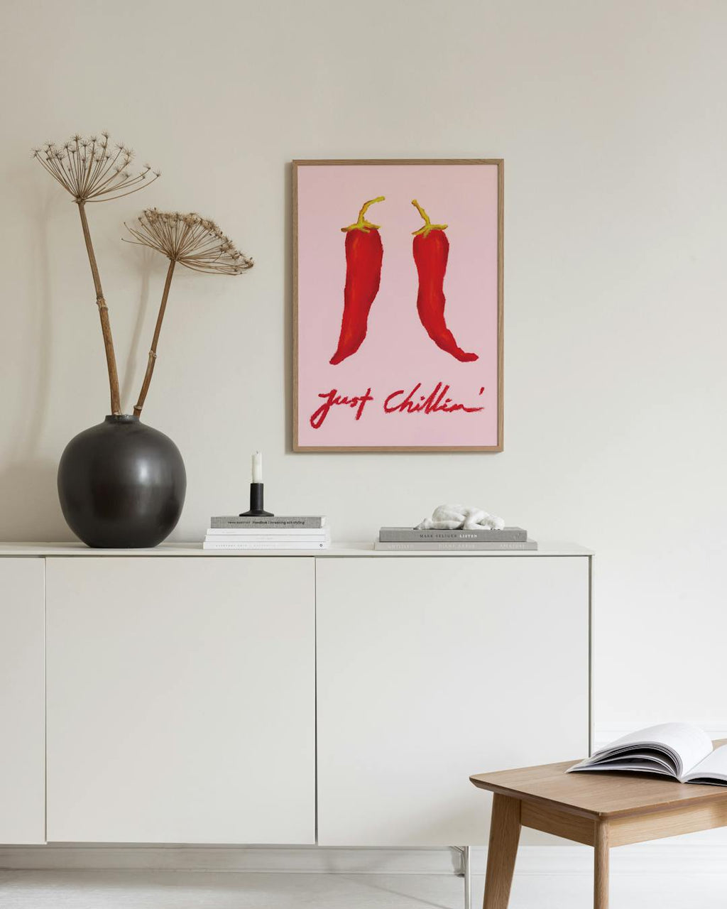 Affiche avec deux piments rouges sur fond rose, et l’inscription just chillin, au-dessus d’un buffet blanc.