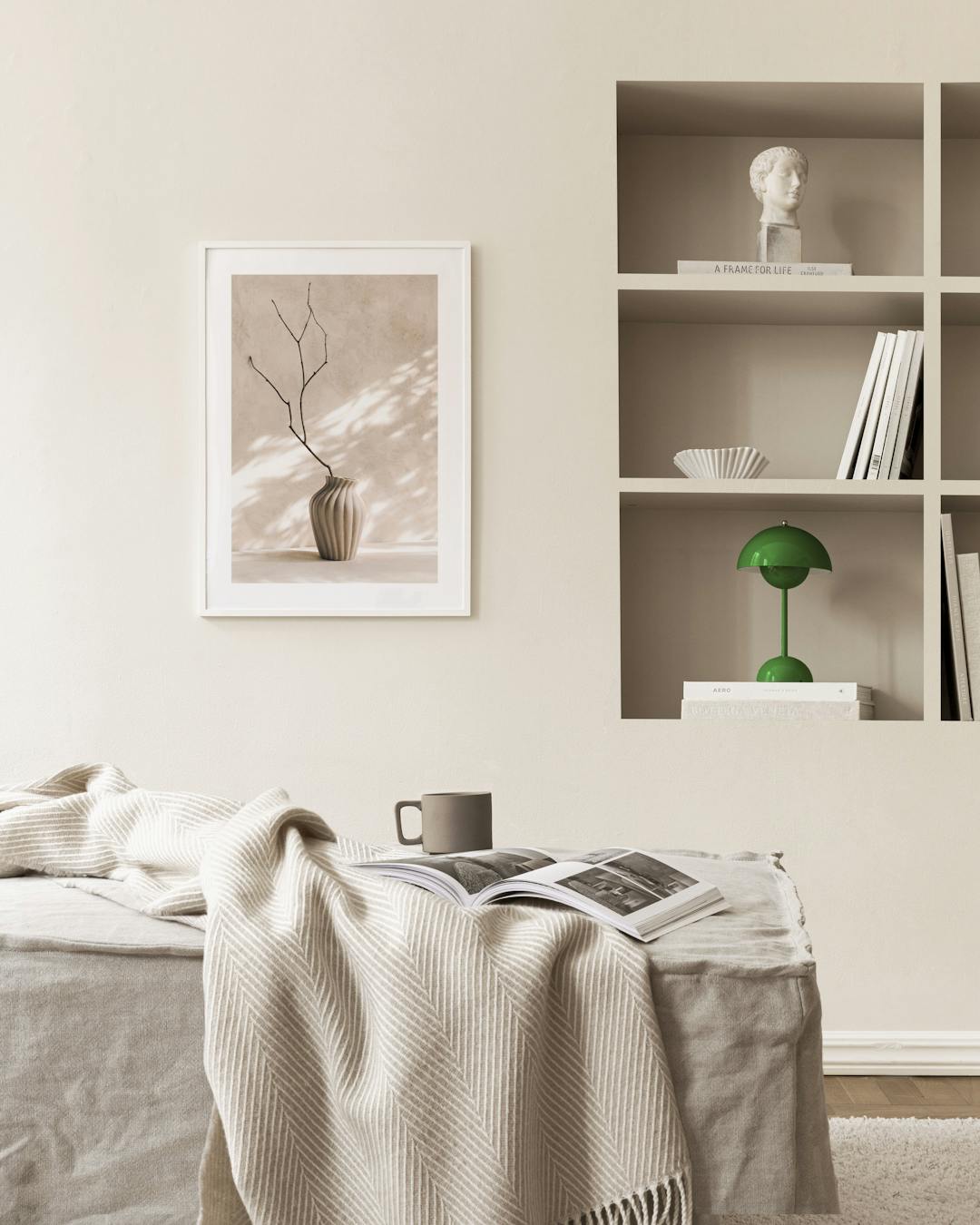 Affiche dun vase beige strié avec une branche sèche, suspendue dans une pièce aux murs clairs.